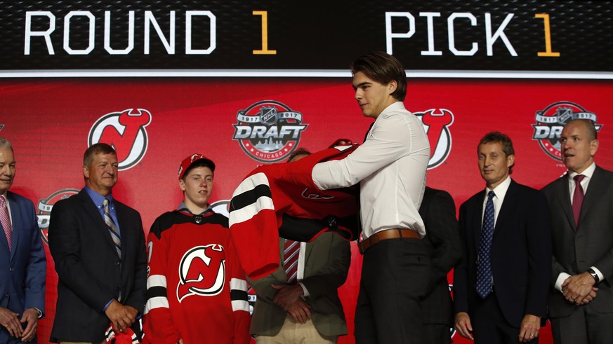 Center Nico Hischier, chosen by the New Jersey Devils in the first round of the NHL hockey draft, puts on a jersey Friday, June 23, 2017, in Chicago. (AP Photo/Nam Y. Huh)