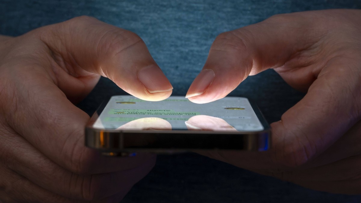 27.02.2025, Thema Smartphone-Nutzung, Frau tippt auf einem Apple iPhone 13.