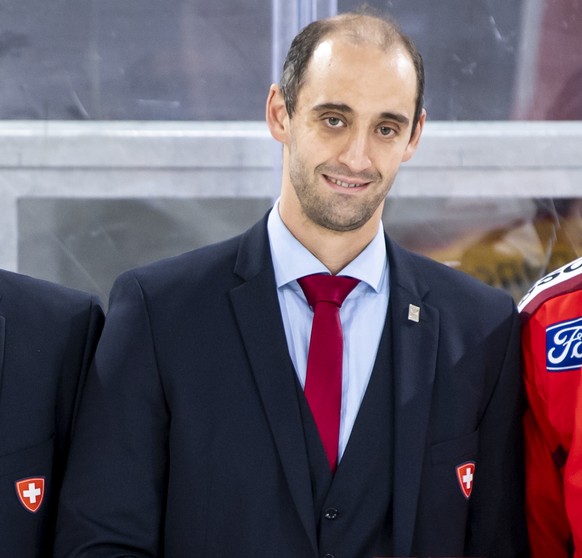 Switzerland&#039;s goalkeeper Reto Berra, left, Switzerland&#039;s defender Romain Loeffel, right, pose with Lars Weibel, director of national teams and Patrick Bloch, CEO of Swiss Ice Hockey Federati ...