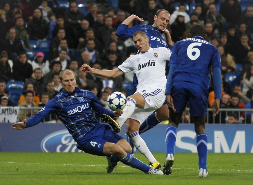 Real Madrid&#039;s Karim Benzema from France, center, controls the ball next to Auxerre Stephane Grichting of Switzerland, left, during their Group G Champions League soccer match at the Santiago Bern ...