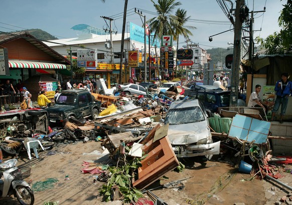 A street is littered with damaged vehicles and debris after the area was hit by tidal waves at Patong beach in Phuket, Thailand, Sunday, December 26, 2004. The most powerful earthquake in 40 years tri ...
