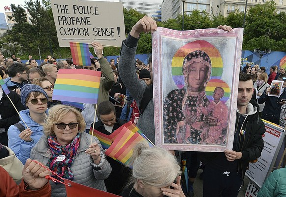 Participants in a protest hold copies of the posters and a giant rainbow flag in support of Elzbieta Podlesna, in Warsaw, Poland, Tuesday, May 7, 2019. Rights groups and government critics in Poland a ...