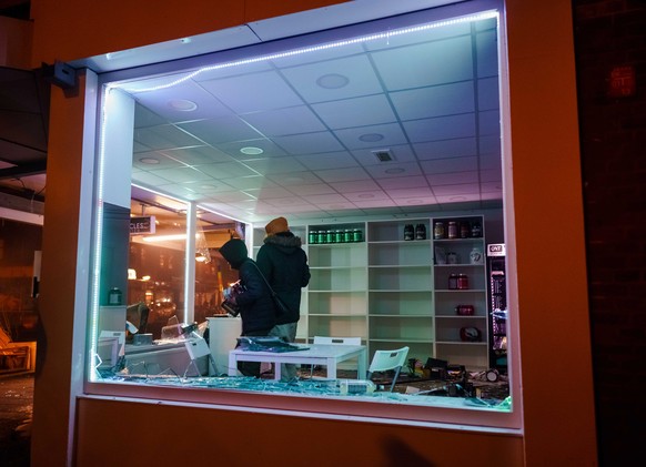 epa08965316 Looting in a shop after a large group of young people has sought confrontation with the police on the Beijerlandselaan in Rotterdam, The Netherlands, 25 January 2021. Police&#039;s mobile  ...