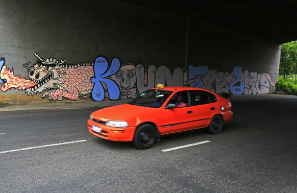 epa06793169 A taxi passes a mural under a bridge in Abidjan, Ivory Coast 06 June 2018 (issued 08 June). A photo study across the three African cities of Abidjan, Monrovia and Cape Town reveal a divers ...