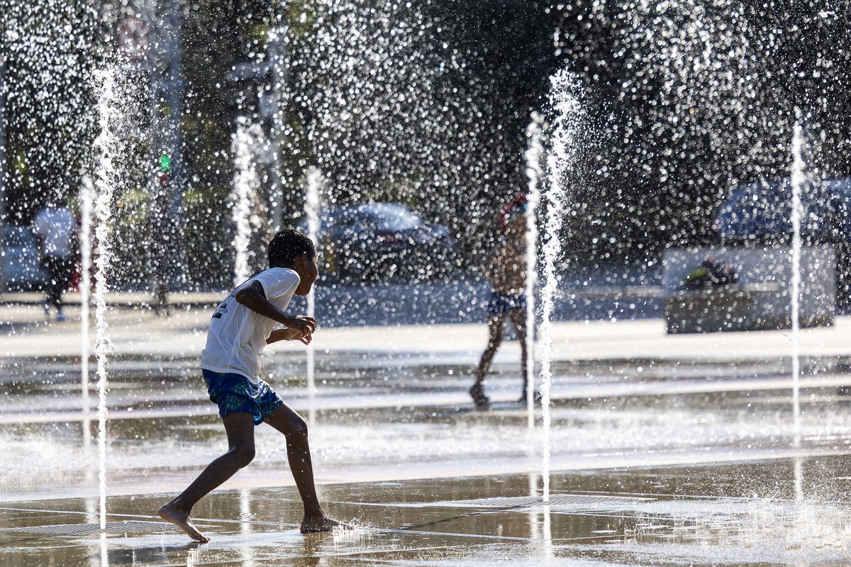 KEYPIX - Un enfant joue dans les jets d'eau de la fontaine de la place des Nations lors de l'alerte canicule, ce vendredi 8 aout 2025 a Geneve. Pour la deuxieme fois cet ete a Geneve, le Ser ...