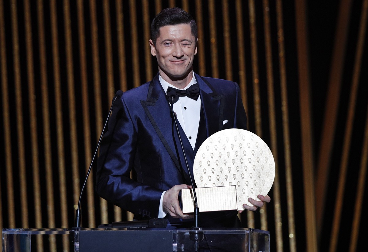 epa09611593 Bayern Munich striker Robert Lewandowski winks after receiving the 2021 Striker of the Year award during the 2021 Ballon d'Or ceremony at Theatre du Chatelet in Paris, France, 29 Nove ...