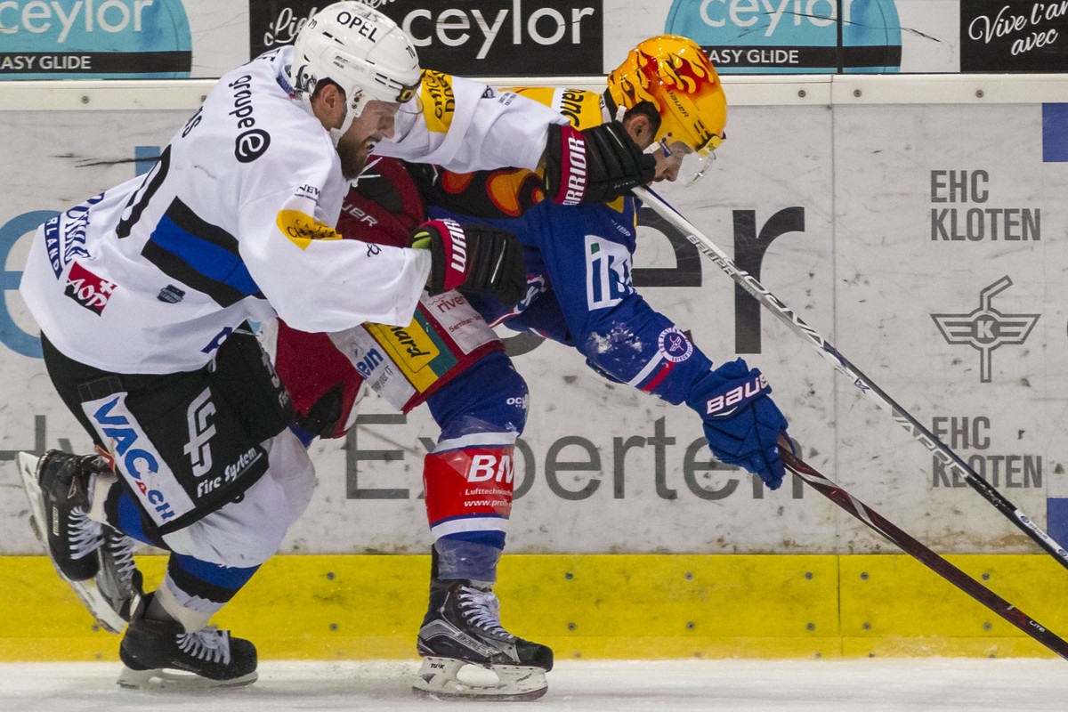 HC Fribourg-Gotteron Verteidiger Jonas Holos, links, gegen EHC Kloten Stuermer Vincent Praplan waehrend dem Eishockey-Meisterschaftsspiel der National League zwischen dem EHC Kloten und dem HC Fribour ...