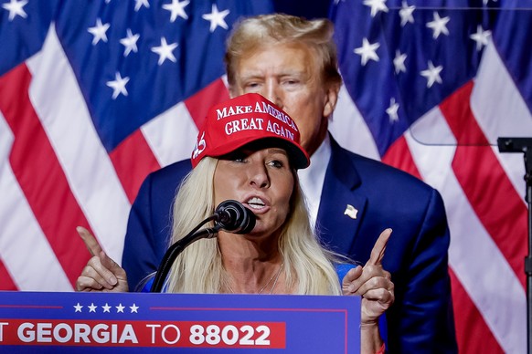 epa11210307 Republican US Representative of Georgia Marjorie Taylor Greene speaks as former US President and Republican presidential candidate Donald Trump looks on during a &#039;Get Out The Vote Ral ...