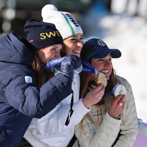 Italy's Federica Brignone, center, celebrates winning gold medal next to joint silver medalists Norway's Thea Louise Stjernesund and Sweden's Sara Hector, left, at the finish area of an ...