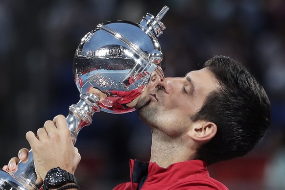 epaselect epa07900302 Novak Djokovic of Serbia kisses his trophy after winning the men&#039;s singles final match against John Millman of Australia at the Japan Open Tennis Championships in Tokyo, Jap ...