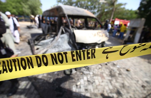 epa09909872 Pakistani security officials inspect the scene of an explosion in Karachi, Pakistan, 26 April 2022. At least Four people were killed inclu?ding Chinese nationals when a vehicle exploded ne ...