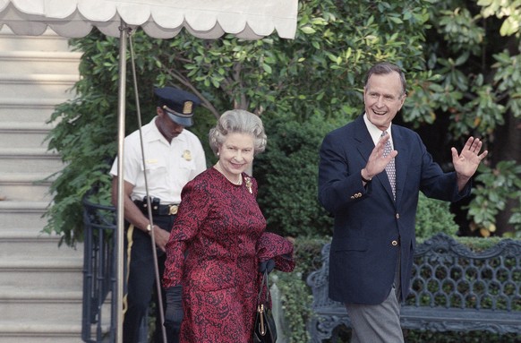 FILE - In this Wednesday, 15, 1991 file photo, US President George H.W. Bush escorts Queen Elizabeth II from the White House to a helicopter enroute to Baltimore to watch her first major league baseba ...