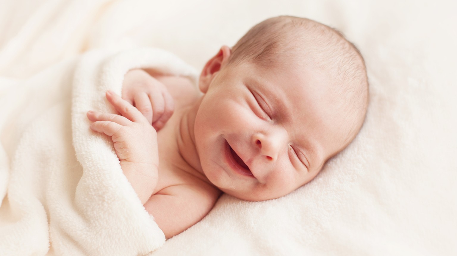 Das Vor- oder Engelslächlen eines sechs Tage alten Babys. Meist verzieht dieser angeborene Reflex das kleine Gesichtlein im Schlaf zu einem Lächeln. Ab der vierten Woche folgt das allgemeine Lächeln u ...