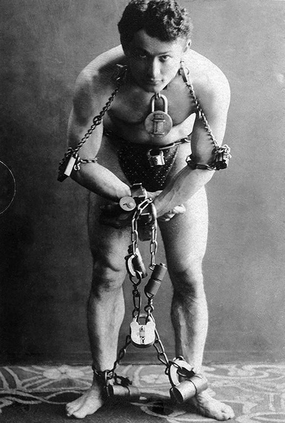 Hungarian-American escape artist and illusionist, Harry Houdini (1874 - 1926) in handcuffs, elbow irons and thumbscrews, courtesy of the Berlin police, Germany, October 1900. (Photo courtesy Library o ...