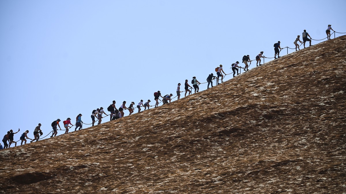 epaselect epa07948053 Tourists climb Uluru, Australia's iconic sandstone formation, in Uluru-Kata Tjuta National Park in Northern Territory, Australia, 25 October 2019. Tourists have been flockin ...