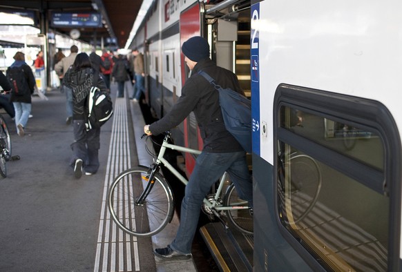 A man steps out of an InterCity train of the Swiss Federal Railways SBB in Biel, Switzerland, with his bike, on November 27, 2009. (KEYSTONE/Gaetan Bally) 

Ein Mann verlaesst am 27. November 2009 im  ...