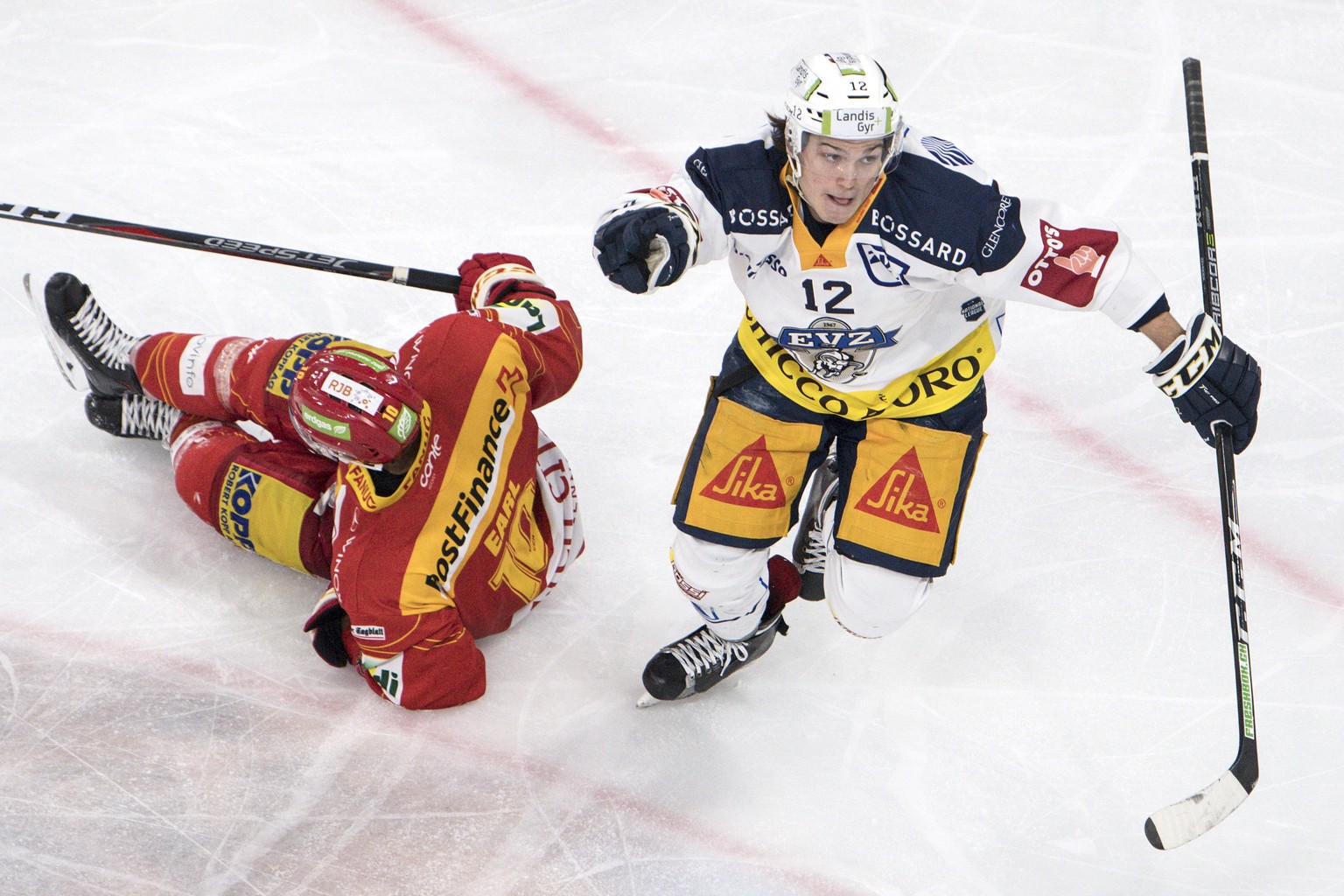 Biels Robbie Earl, links, liegt am Boden, Zugs Yannick Zehnder feiert den Treffer zum 2:2 im Eishockey Meisterschaftsspiel der National League zwischen dem EHC Biel und dem EV Zug, am Samstag, 24. Nov ...