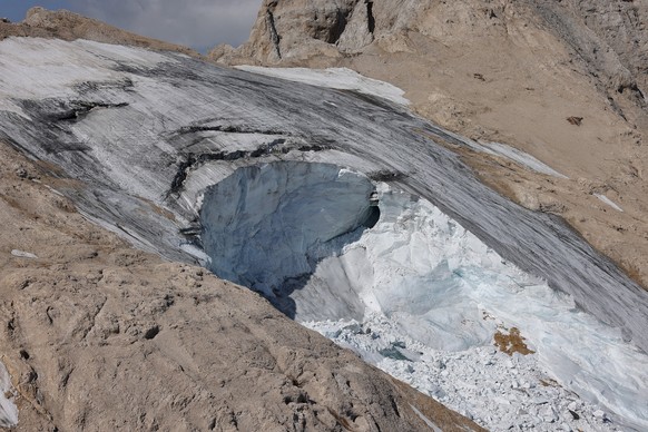 epa10052874 A photo taken from a helicopter shows the missing part of a glacier that collapsed on 03 July triggering an avalanche on the Marmolada Mountain in Canazei, Italy, 05 July 2022. At least se ...