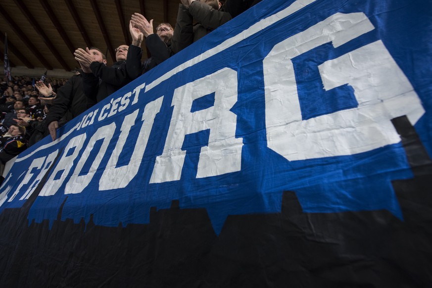 Les supporters fribourgeois chantent devant une banderole &quot;Ici c&#039;est Fribourg&quot;, lors du 1er match de la finale de Play-out du championnat suisse de hockey sur glace de National League A ...