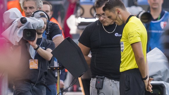 L?abitre Sandro Schaerer regarde la VAR, lors de la rencontre de football de Super League entre le FC Sion et le FC Basel 1893 ce vendredi 19 juillet 2019 au stade de Tourbillon a Sion. (KEYSTONE/Jean ...