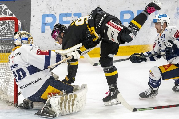 Ajoies Kevin Bozon, Mitte, gegen Zugs Torhueter Leonardo Genoni, links, und Zugs Lino Martschini, rechts, beim Eishockey-Qualifikationsspiel der National League zwischen dem HC Ajoie und dem EV Zug in ...