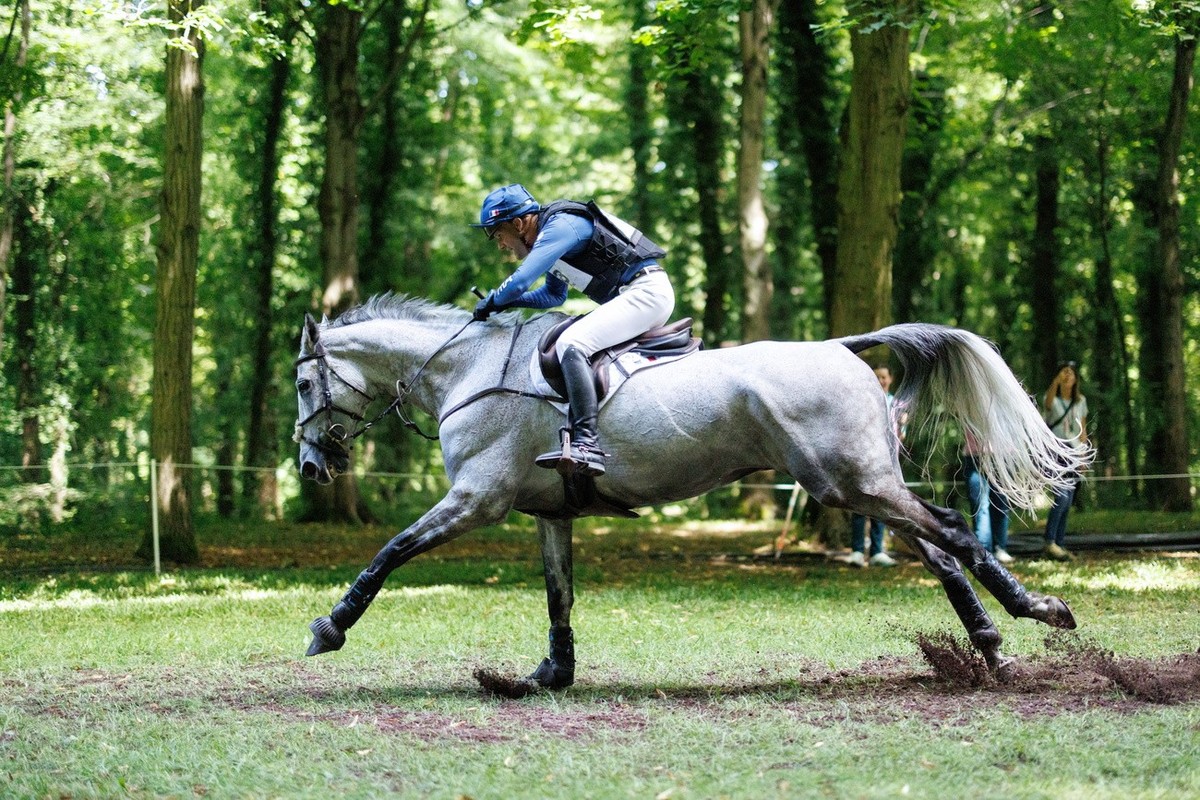 epa11503495 Nicolas Touzaint of France jumps over a course obstacle with his horse Diabolo Menthe during the Eventing Cross Country Team and Individual competition of the Equestrian Eventing competiti ...