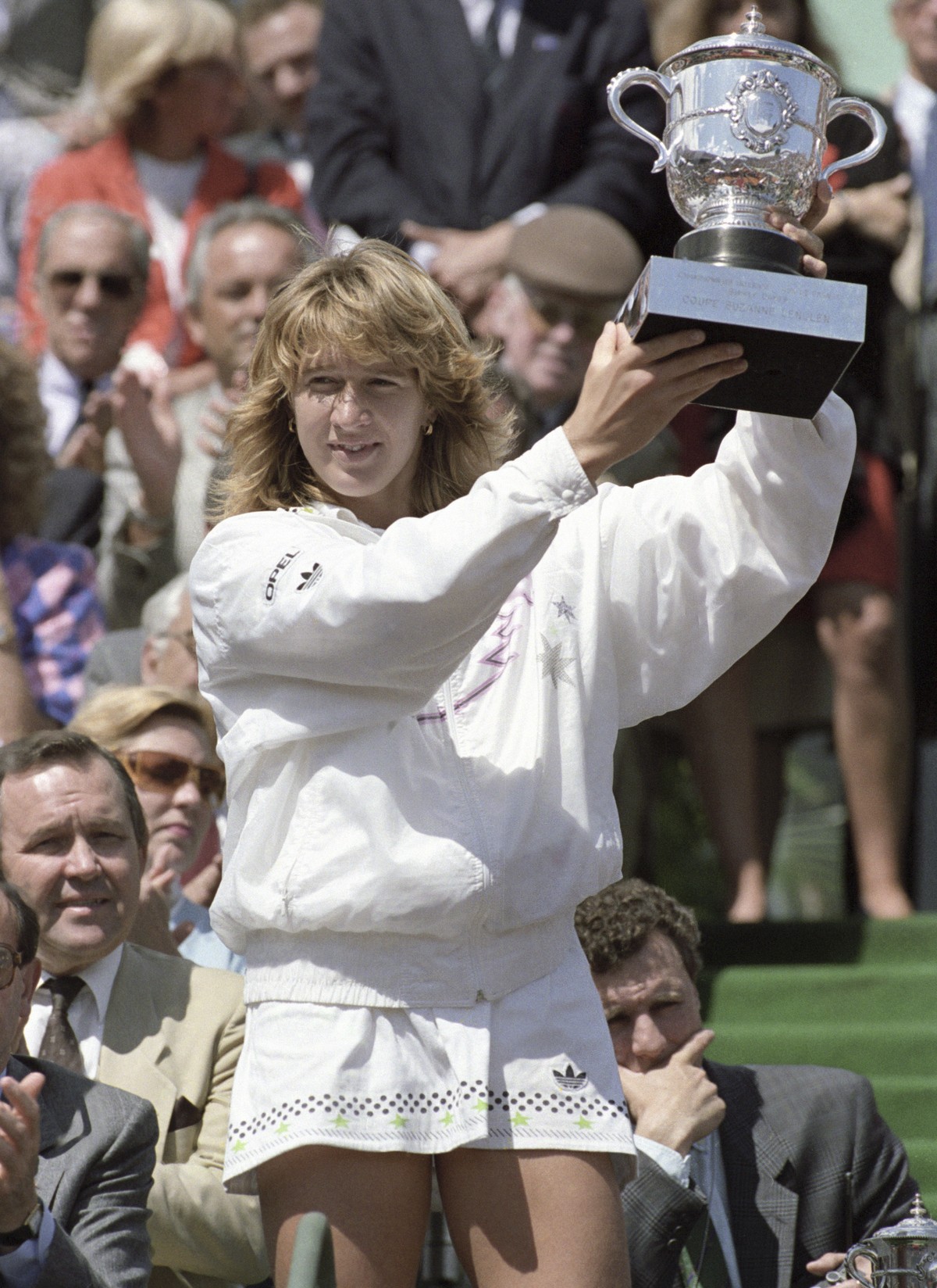 FILE - West Germany's Steffi Graf holds holds up her Suzanne Lenglen winner's trophy after her victory over Natalia Zvereva of the Soviet Union in the French Open tennis tournament, June 4,  ...