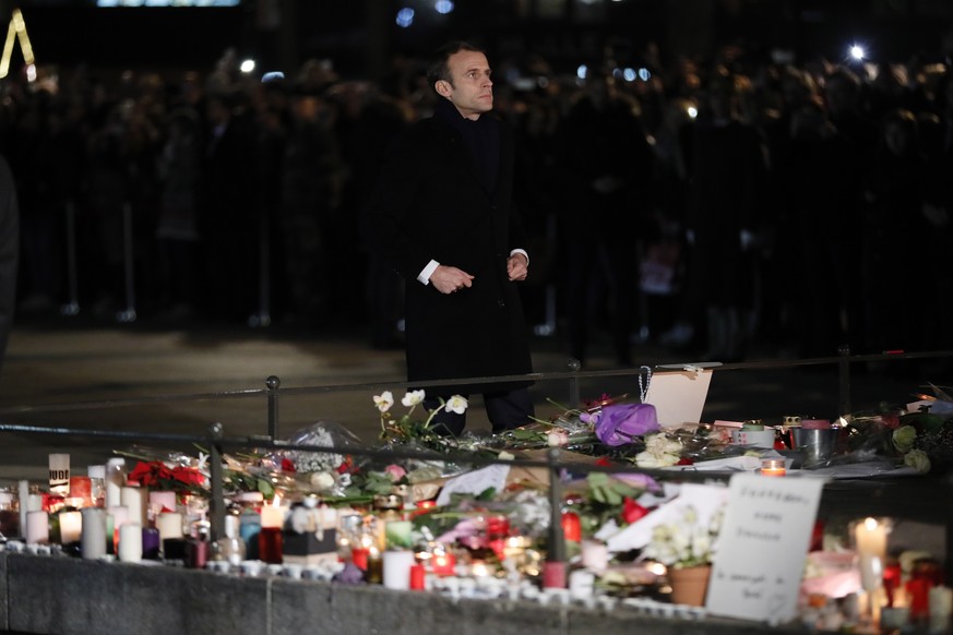 epa07231706 French President Emmanuel Macron pays tribute at a makeshift memorial to the victims of the Christmas Market terror attack shooting, in Strasbourg, France, 14 December 2018. Cherif Chekatt ...