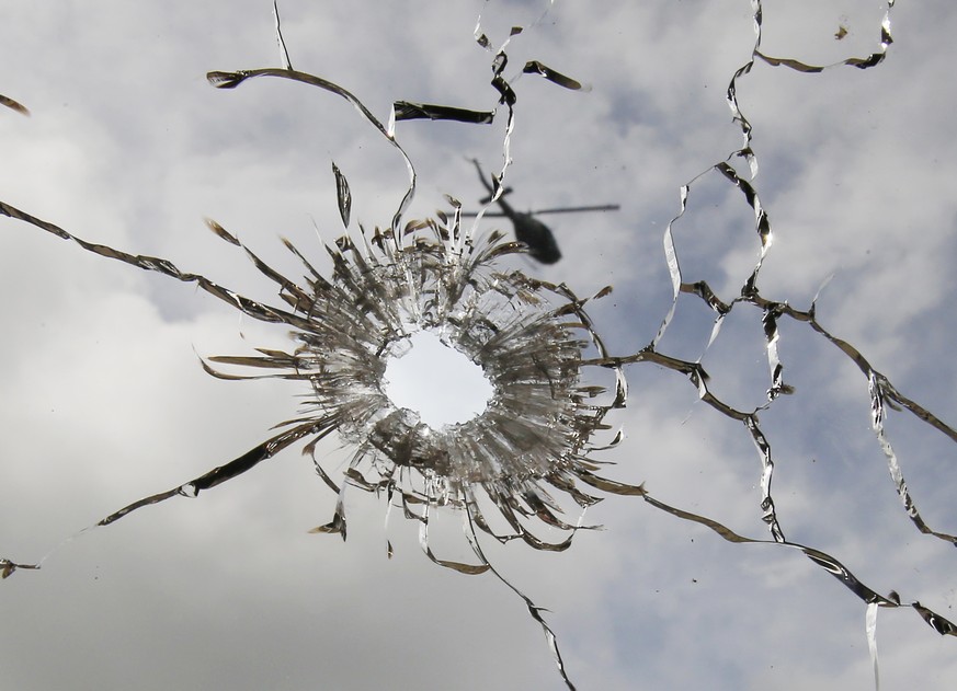 A helicopter hovering is seen through a window glass with a bullet hole in a building at the site of an earlier gunbattle between government forces and Muslim militants in Marawi Monday, May 29, 2017  ...