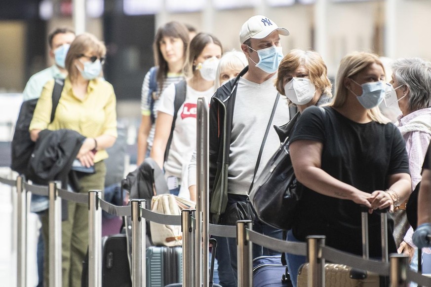 Fluggaeste warten mit Atemschutzmasken vor einem Check-In Schalter aufgenommen anlaesslich des Schutzkonzeptes vom Flughafen Zuerich, aufgenommen am Donnerstag, 28. Mai 2020 in Zuerich. (KEYSTONE/Enni ...