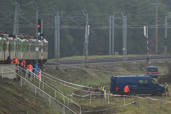 epa12531366 Special forces and police investigate at the scene of a destroyed section of railway tracks on the Deblin-Warsaw route near the Mika railway station, central Poland, 17 November 2025. Poli ...