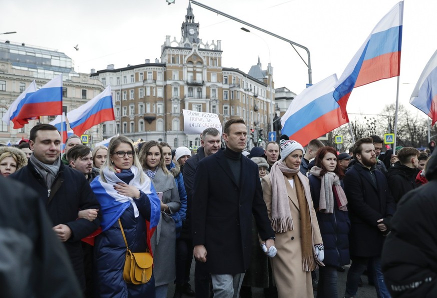 Russian opposition activist Alexei Navalny, center, his wife Yulia, right of him, and opposition activist Lyubov Sobol, second from left, take part in a march in memory of opposition leader Boris Nemt ...