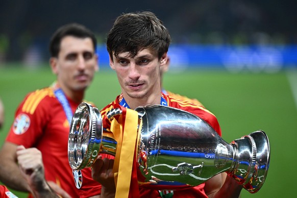 BERLIN, GERMANY - JULY 14: Robin Le Normand of Spain celebrates with the trophy after his team s victory during the UEFA EURO, EM, Europameisterschaft,Fussball 2024 final match between Spain and Engla ...