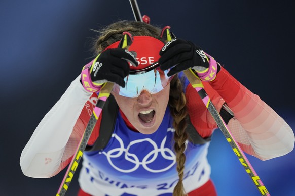 Lena Haecki of Switzerland reacts after crossing the finish line during the women&#039;s 7.5-kilometer sprint competition at the 2022 Winter Olympics, Friday, Feb. 11, 2022, in Zhangjiakou, China. (AP ...