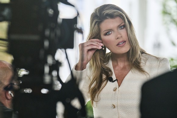 Lindsey Halligan, special assistant to the president, fixes an earring at the end of an interview outside of the White House, Wednesday, Aug. 20, 2025, in Washington. (AP Photo/Jacquelyn Martin)
Linds ...