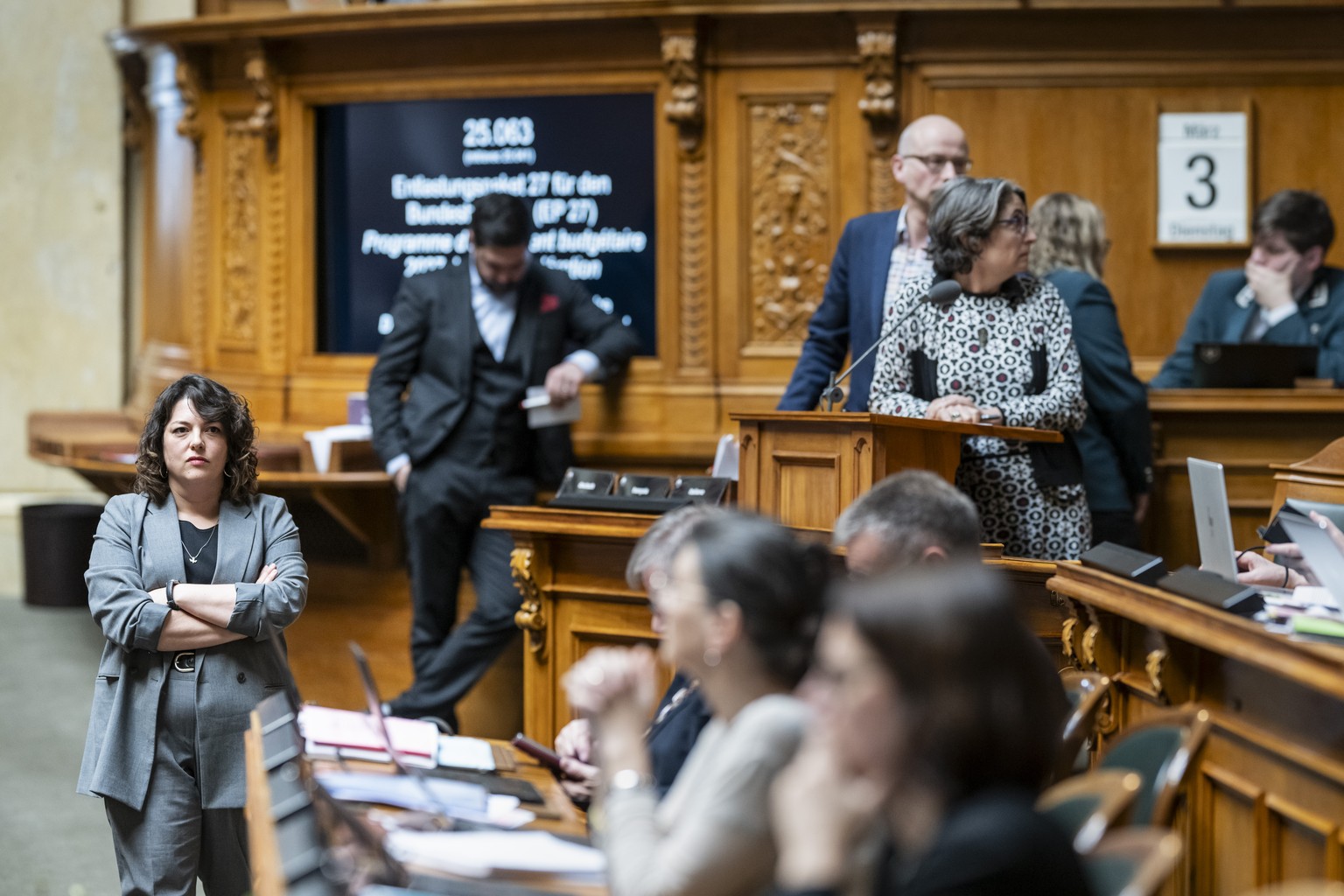 Tamara Funiciello, SP-BE, links, hoert einem Votum zu, waehrend der Debatte um das Entlastungspaket 27, EP 27, an der Fruehjahrssession der Eidgenoessischen Raete, am Dienstag, 3. Maerz 2026 im Nation ...