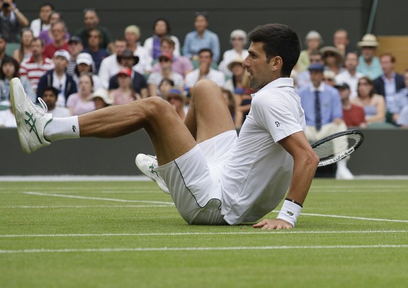 Serbia&#039;s Novak Djokovic falls after returning the ball to Ugo Humbert of France in a men&#039;s singles match during day seven of the Wimbledon Tennis Championships in London, Monday, July 8, 201 ...