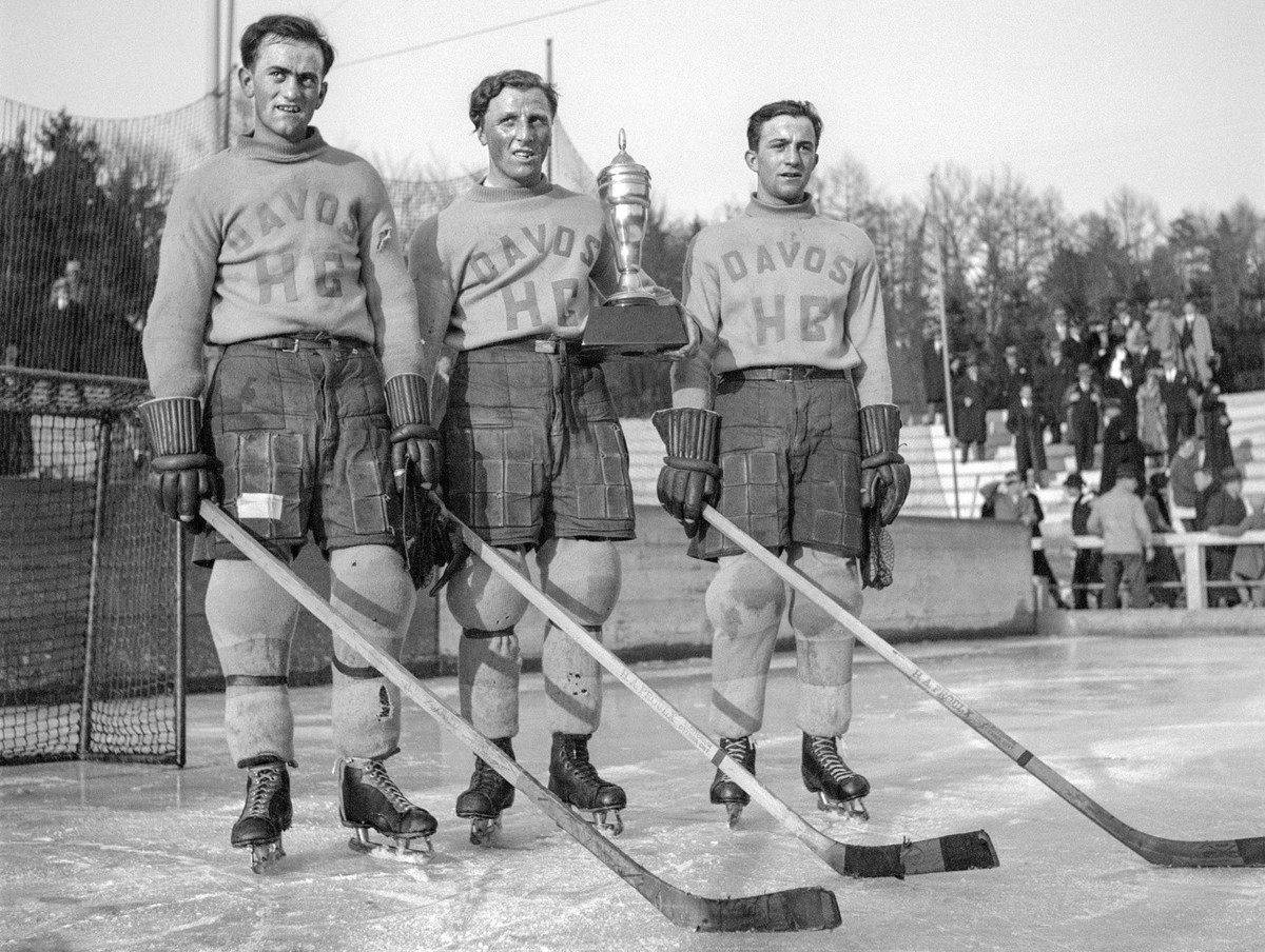 The players of the legendary "ni" forward line of "HC Davos" - Hans Cattini, Bibi Torriani, Pic Cattini (from left to right) - pose with the cup after winning the first Swiss champ ...