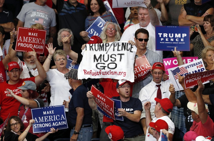 epaselect epa06109716 Supporters summon event security staff to remove a protester (C) as US President Donald J. Trump (not pictured) speaks during a &#039;Make America Great Again&#039; rally at the  ...