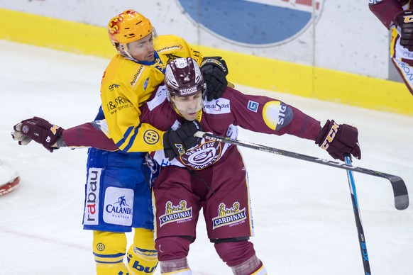 Le joueur de davos, Broc Little, gauche, a la lutte avec le joueur genevois, Daniel Rubin, droite, lors du match du championnat suisse de hockey sur glace de National League, entre le Geneve Servette  ...