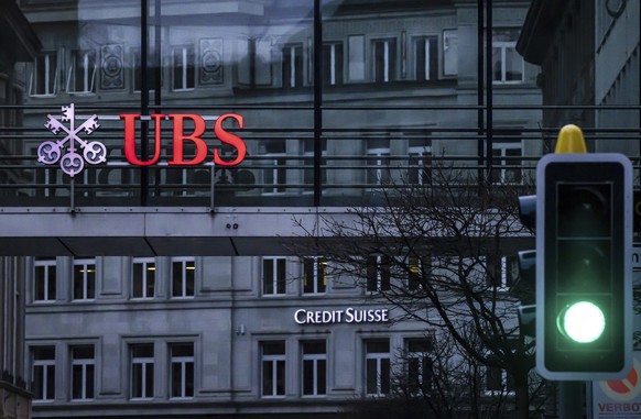 FILE - A traffic light signals green in front of the logos of the Swiss banks Credit Suisse and UBS in Zurich, Switzerland, on March 19, 2023. Swiss banking giant UBS said Tuesday it took in $28 billi ...