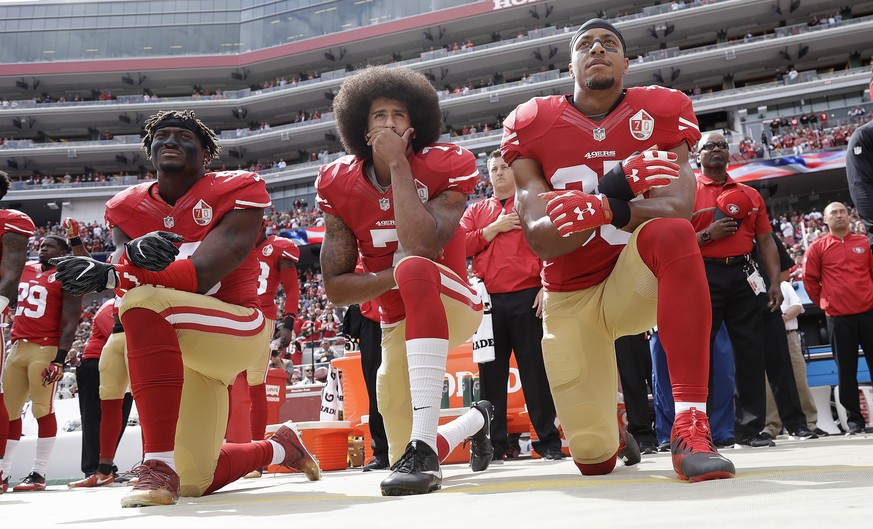 FILE - In this Oct. 2, 2016 file photo, from left, San Francisco 49ers outside linebacker Eli Harold, quarterback Colin Kaepernick and safety Eric Reid kneel during the national anthem before an NFL f ...