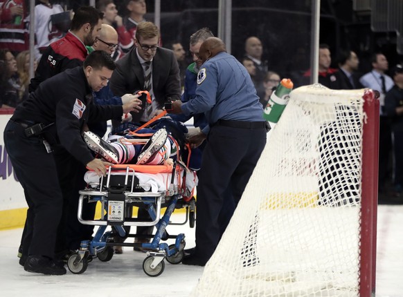 Vancouver Canucks defenseman Philip Larsen, of Finland, is carried onto a stretcher after a hit by New Jersey Devils left wing Taylor Hall during the second period of an NHL hockey game, Tuesday, Dec. ...