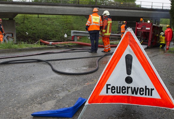 Die Feuerwehr richtet eine Pumpe ein, um das angesammelte Wasser bei einer Eisenbahntrasse ablaufen zu lassen, am Dienstag, 28. April, 2015, in der Naehe von Rotkreuz. (KEYSTONE/Anthony Anex)
