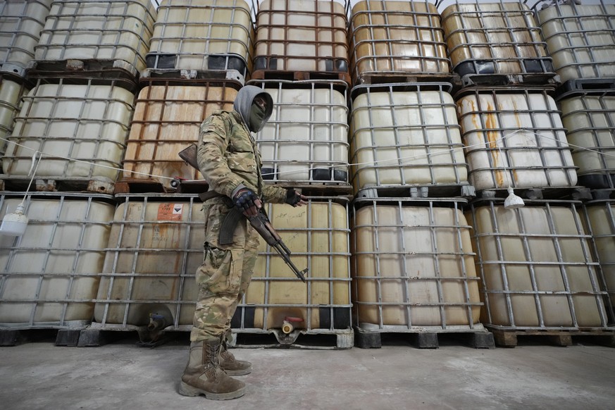 A Syrian member of the rebel group shows liquid material for manufacturing amphetamine pills known as Captagon hidden, at the warehouse where the drug was manufactured before the fall of Bashar Assad  ...