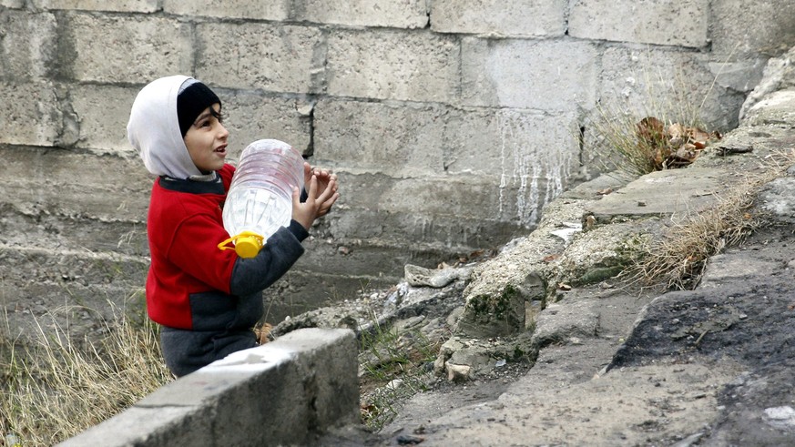 epa05690769 A Syrian boy holds his jerry-can filled with water in Damascus, Syria, 29 December 2016. According to media reports, the capital Damascus has been suffering of water shortage for seven con ...