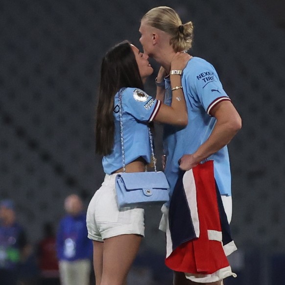 epa10684481 Erling Haaland (R) of Manchester City and his girlfriend Isabel Johansen stand on the pitch after winning the UEFA Champions League Final soccer match between Manchester City and Inter Mil ...