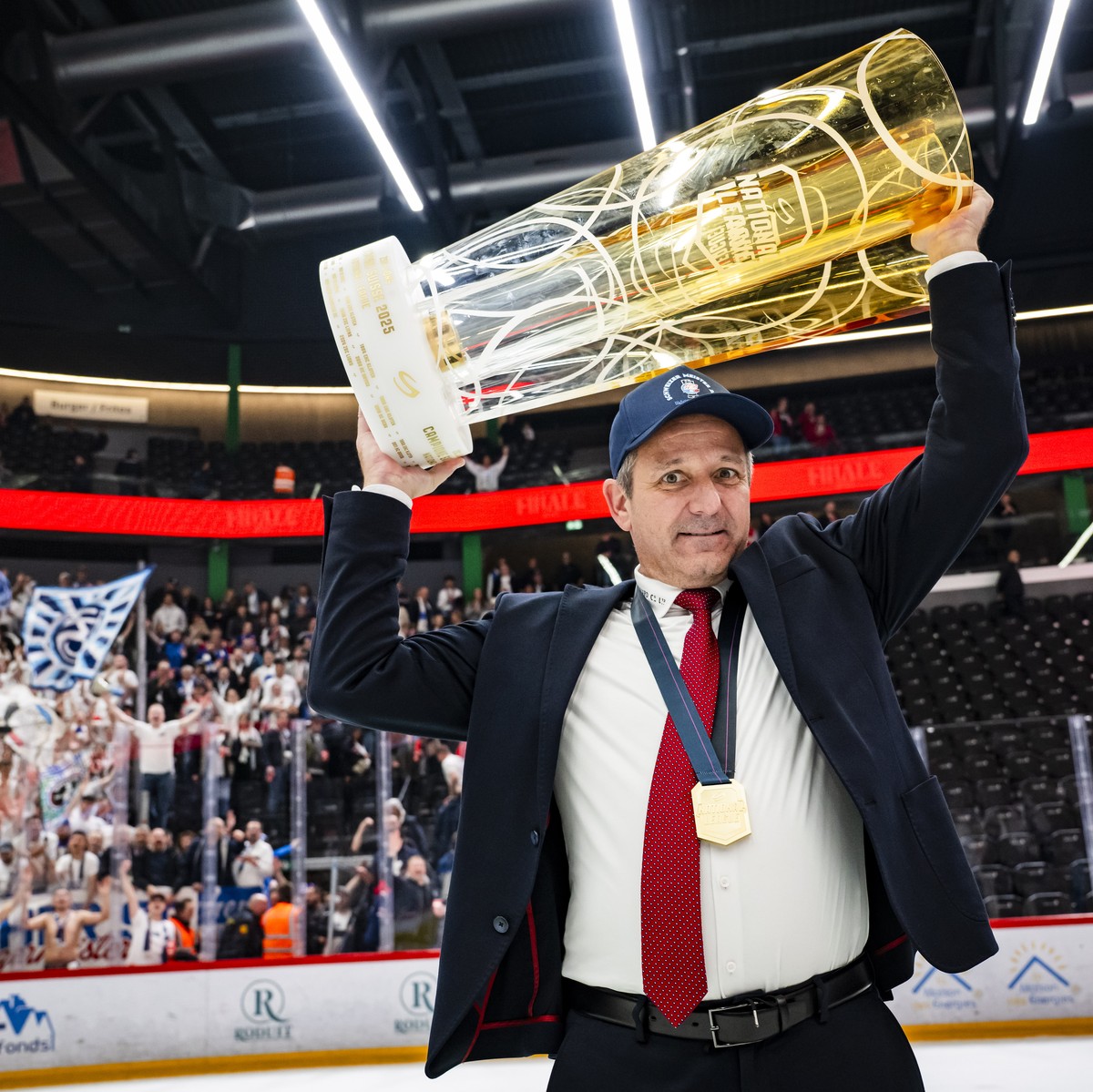 ZSC Lions' Head coach Marco Bayer celebrates with the trophy of Swiss Champion after winning by 2:3 during the fifth leg of the National League Swiss Championship final playoff game between Lausa ...