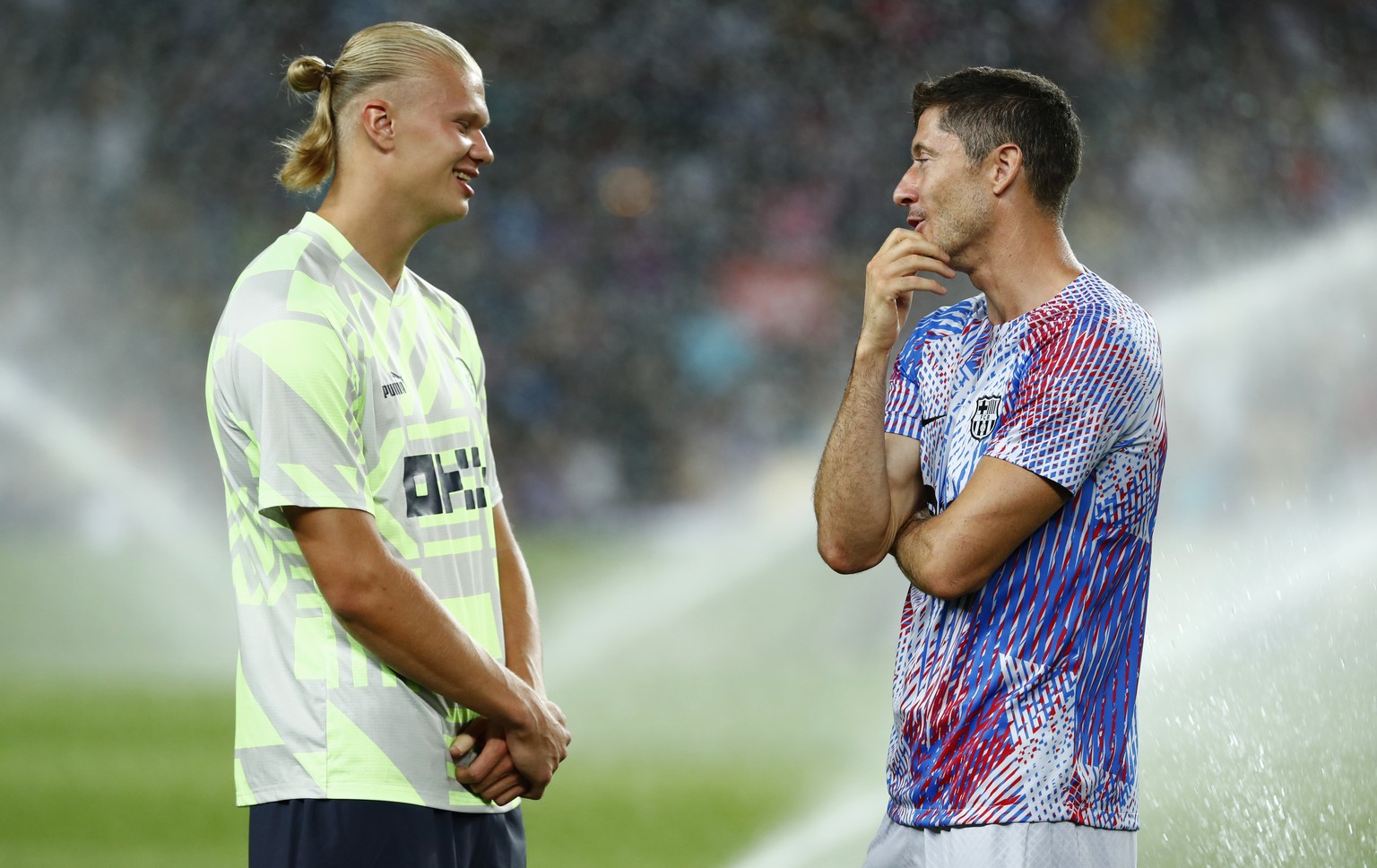 Manchester City&#039;s Erling Haaland, left, speaks with Barcelona&#039;s Robert Lewandowski ahead of a charity friendly soccer match between Barcelona and Manchester City at the Camp Nou stadium in B ...