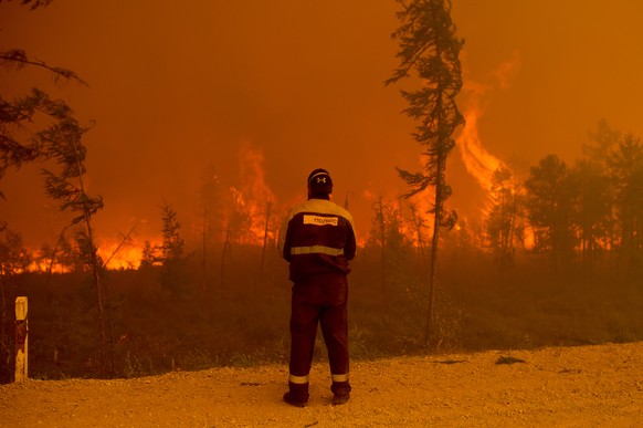 A firefighter stands at the scene of forest fire near Kyuyorelyakh village at Gorny Ulus area west of Yakutsk, in Russia, Saturday, Aug. 7, 2021. Wildfires in Russia&#039;s vast Siberia region endange ...